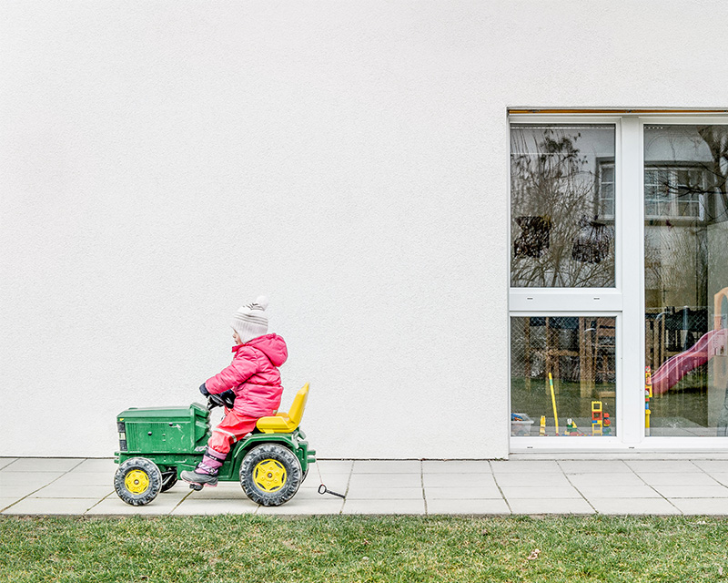 Kind auf Traktor vor Kindertagesstätte Uhunäscht